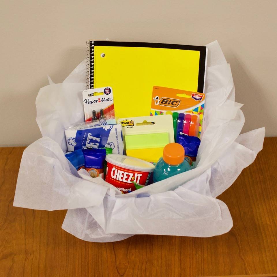 Scavenger hunt winner prize basket includes a notebook, pens, highlighters, sticky notes, Gatorade, granola bars, flash cards, popcorn, and cheese its.